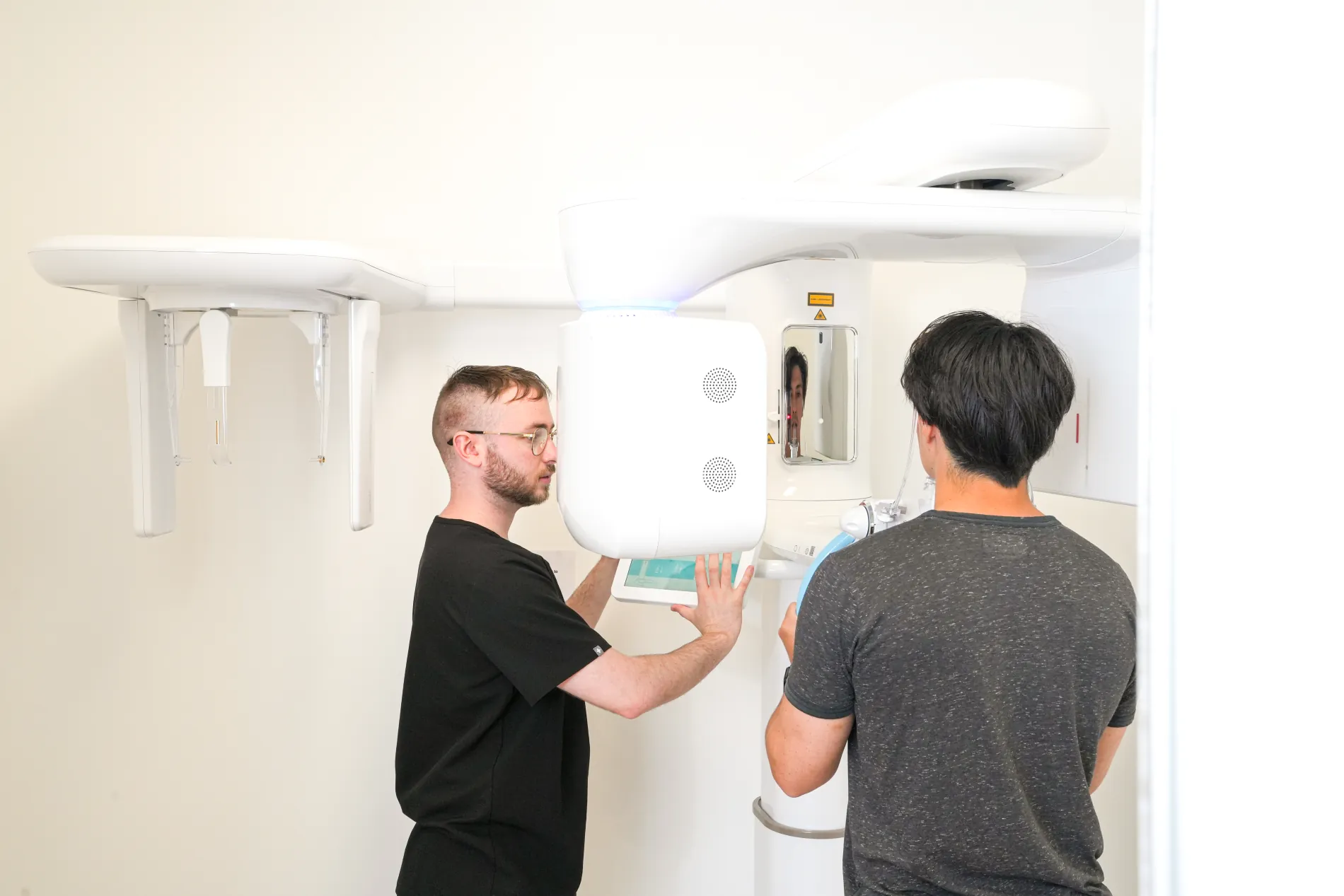 Two clinicians positioning a patient at a practice 3D imaging unit