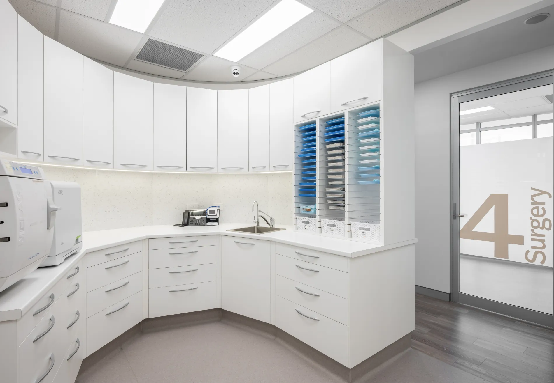 Prepared instrument trays and sterilisation equipment beside a surgery room door